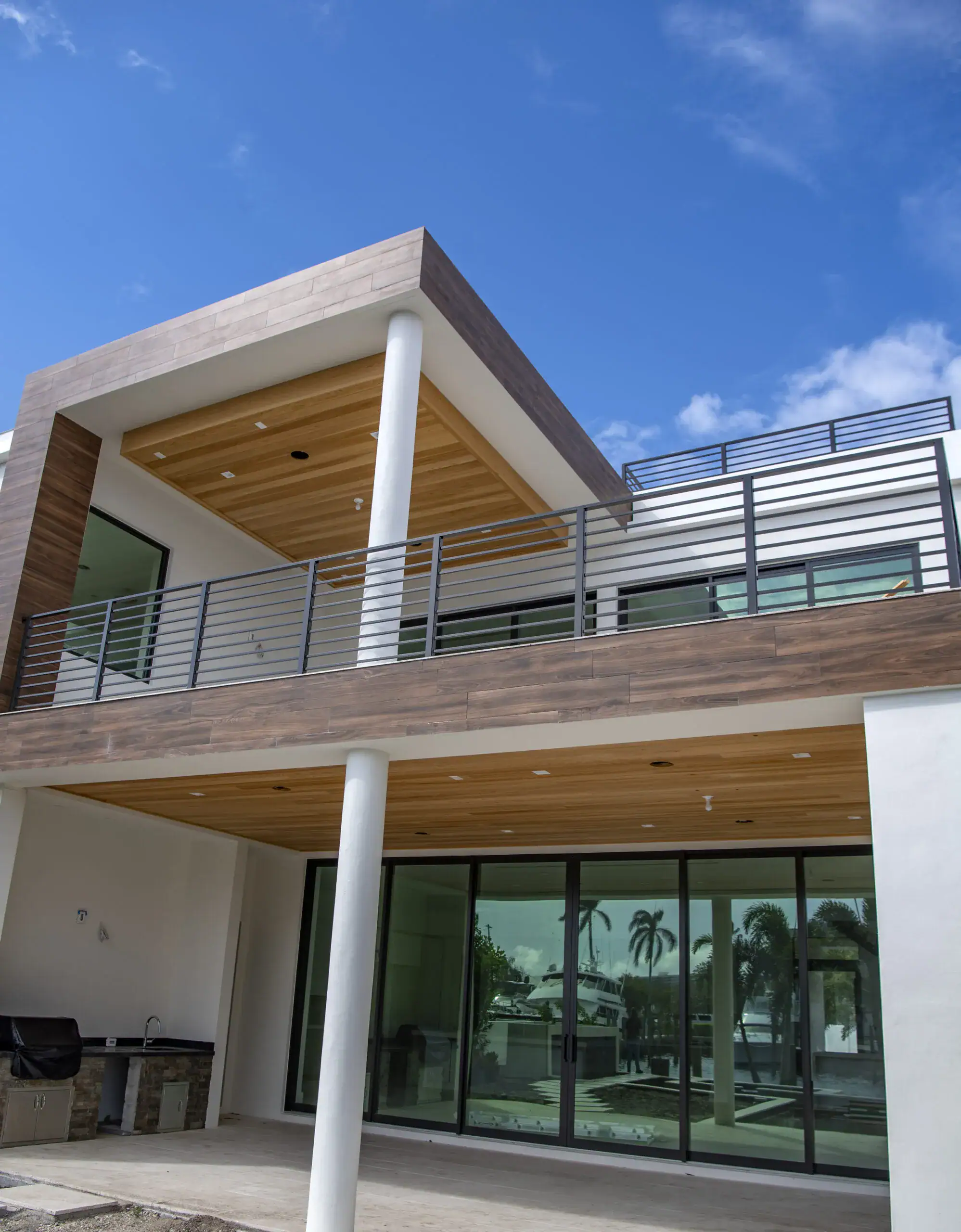 upward view of two story house with balcony and elegant glass patio door